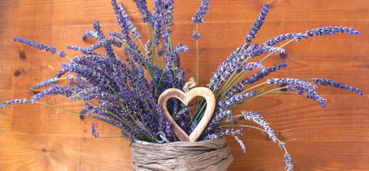 Lavendel mit Herz in der Vase Hintergrund Holz Landhausstil