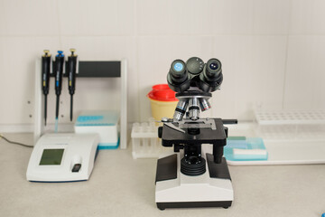 Fototapeta na wymiar laboratory equipment: medical microscope, micropipette, and urine strip analyser