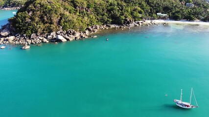 Naklejka premium Boat near tropical shore. Amazing drone view of modern yacht sailing on calm sea water near coast of tropical volcanic island. Exotic Paradise Koh Samui, Silver Beach.