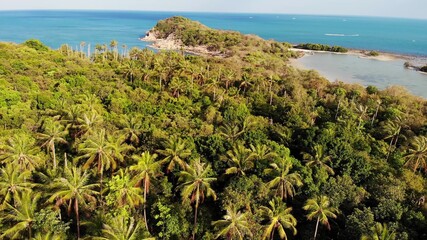 Small island and coral reef in ocean. Drone view of green uninhabited island and amazing coral reef in calm sea on sunny day in tropical nature. Koh Samui, Thailand.