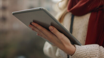 Closeup woman hands serfing internet on tablet computer outdoors.