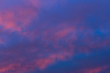 The crimson sunset. Purple glow on the evening clouds. Sky and clouds as background.