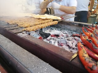 Cooking Adana kebabs on the restaurant style grill