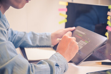 Businessman use tablet for analyzing stock chart finance and banking profit graph and order sell or buy Stock trading selective focus on hand