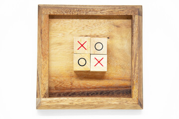 O and X wooden block use for tic tac toe game lay in center of the wooden frame on white background...
