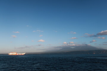 Fototapeta premium A Sunny Morning in The Bali Strait, With The Background of Mount Ijen and Mount Raung