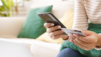Close up woman hand using mobile phone and credit card to make payment and online shopping