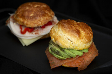 Assortment of homemade scones with ham, cheese, avocado, salmon, cream cheese and strawberry jam