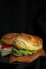 Assortment of homemade scones with ham, cheese, avocado, salmon, cream cheese and strawberry jam