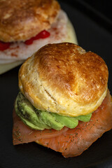 Assortment of homemade scones with ham, cheese, avocado, salmon, cream cheese and strawberry jam