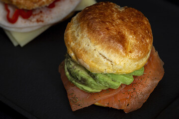 Assortment of homemade scones with ham, cheese, avocado, salmon, cream cheese and strawberry jam