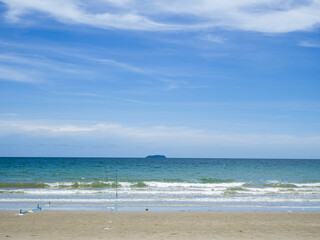Fototapeta na wymiar The sand beach and the wave of sea with blue sky with cloud