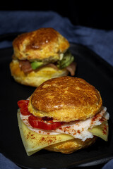 Assortment of homemade scones with ham, cheese, avocado, salmon, cream cheese and strawberry jam