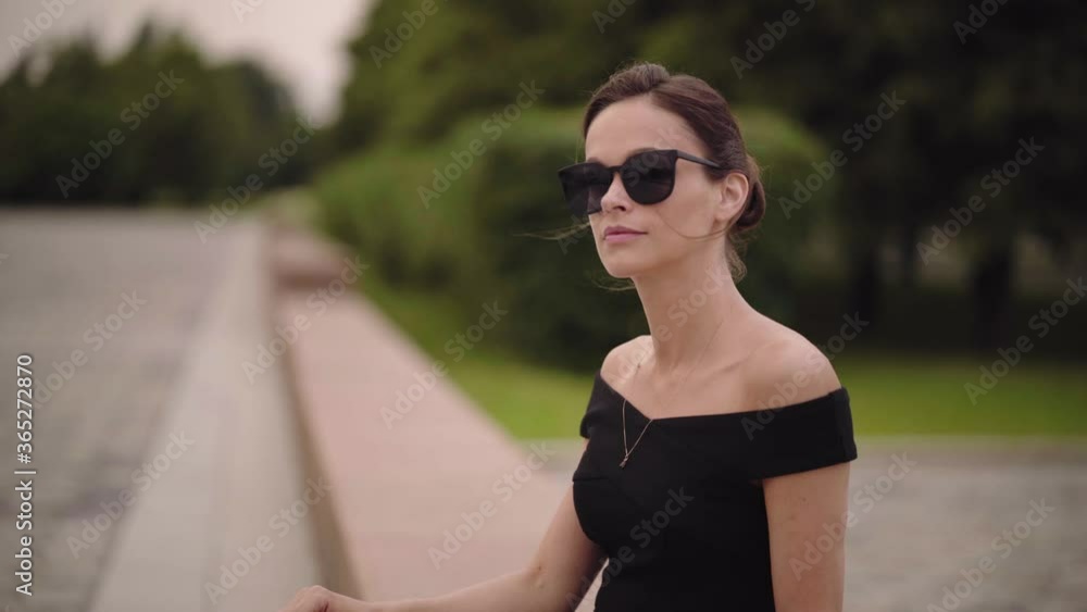 Poster beautiful woman is wearing sunglasses on the street