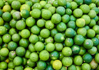 Closeup photo of lime pile on shelf. Texture background of fresh ingredient in gourmet market.