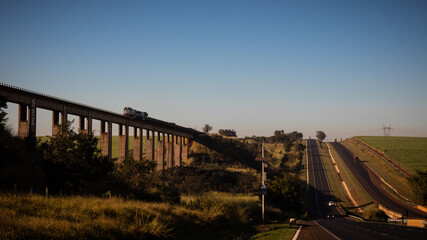 Train with a highway with blue sky