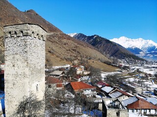 Fototapeta premium Winter Georgia. Svaneti Region, mountain city Mestia. Svan Towers. View from above, perfect landscape photo, created by drone. Aerial photo from travel.
