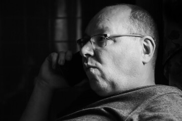 Fototapeta premium Black and white portrait of a man emotionally talking on the phone.