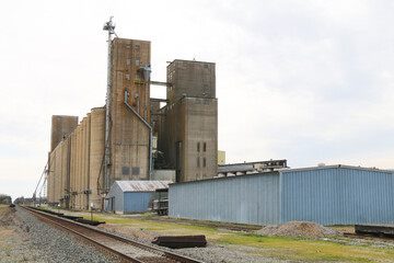 very large working agricultural farm community feed grain and corn silo building next to railroad track in rural heartland america perfect for farming and agriculture stock imagery