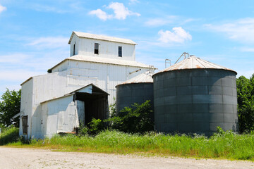 Fototapeta na wymiar co-op agricultural feed grain and corn silo farm storage building against a blue sky in rural heartland america perfect for industry farming and commercial agriculture marketing