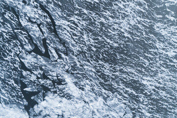 Fototapeta premium Aerial view of a frozen lake surface. Aerial Snow pattern on the frozen lake. Aerial photography. Winter ice texture.