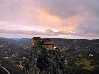 Obraz premium Beautiful aerial drone photography. Country Georgia from above. Mountain Monastery and Church of Katskhi, Chiatura region. Sunset aerial view