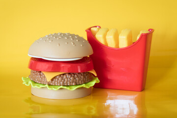 Meat hamburgers and French fries, Backgrounds. plastic burger and fries on yellow background.