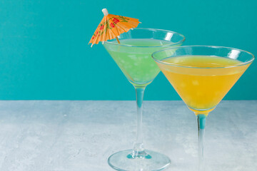 Glasses of assorted fruit non-alcoholic cocktails on a bright background with an umbrella. Health drinks.