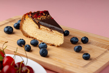 Piece of cheesecake with chocolate top and berries