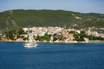 Fototapeta na wymiar The historical town on Skiathos island seen from the boat when entering the harbour in summer light.