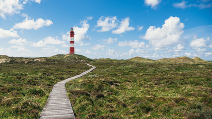 Leuchtturm in den Dünen auf der Insel Amrum mit Bohlenweg
