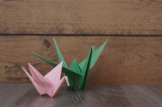 two origami cranes on wooden