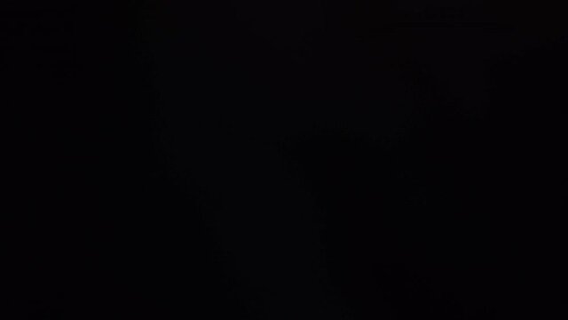 abstract smoke loop, cool lens flares on dark background in 4k.
