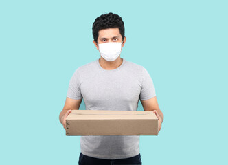 Handsome Asian man wearing face mask to protect from germ and virus. holding with parcel post box...