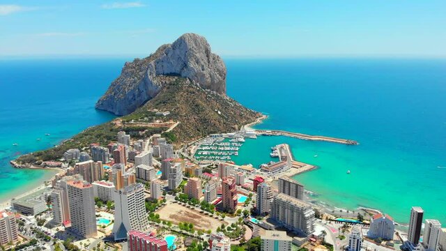 Aerial drone point of view real time of Calpe cityscape, Penyal d'Ifac or Ifach Natural Park rocky mountain landmark, Province Alicante, Costa Blanca, Valencia, Spain