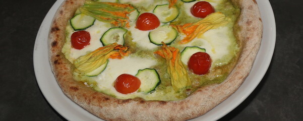 Pizza con mozzarella fiori di zucca, pomodorino, e pesto