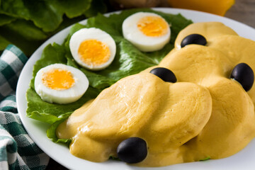 Traditional Peruvian papa a la huancaina on wooden table. Close up	