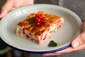 male hands holding a plate of pie.