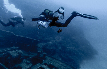 Fototapeta na wymiar Scubadiving. Scuba divers diving at the shipwreck.