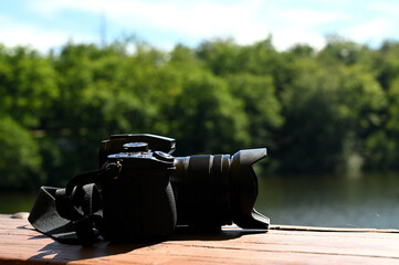 Black camera with a lake as background