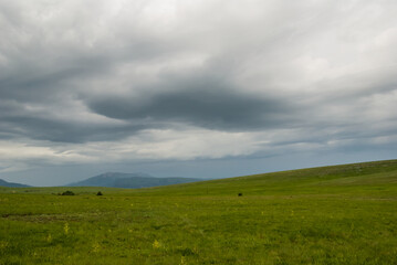 Fototapeta na wymiar green hills under a dense cloudy sky