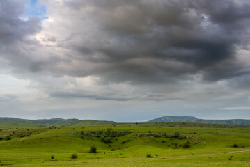 Fototapeta na wymiar green hills under a dense cloudy sky