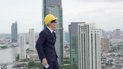 Happy young Asian businessman office worker using mobile phone discussion with colleague teamwork for success project. Successful business man entrepreneur working with wireless technology in the city