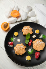 profiteroles cake with pistachio cream. On a white wooden table
