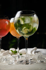 Assorted cold cocktails - mojito, orange and raspberry. On a wooden, white table
