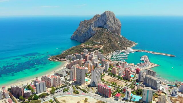 Aerial drone point of view real time of Calpe cityscape, Penyal d'Ifac or Ifach Natural Park rocky mountain landmark, Province Alicante, Costa Blanca, Valencia, Spain