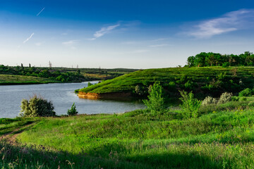 Fototapeta na wymiar Landscape with a wide river and lots of green vegetation. Rostov oblast, the river Grushevka. Warm summer season, spring, everything blooms and smells, Sunny clear day