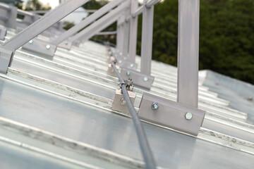 Elements of the roof fence fastening, steel clamps installed on the galvanized roof.