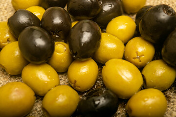 Green olives and black olives the texture of the surface. Close up.