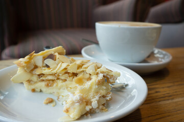 A cup of coffee with a piece of cake